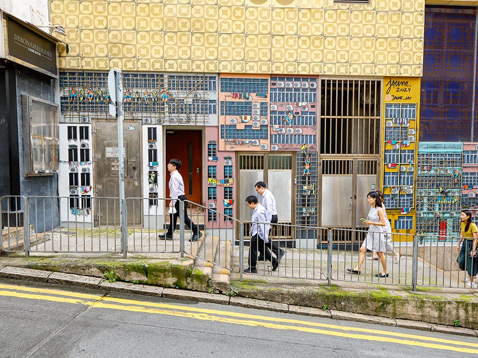 人们走过中环Jaune创作的街头壁画。