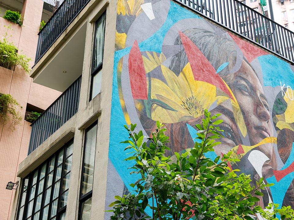 大楼侧面和树后有Kogaone创作的彩色壁画。