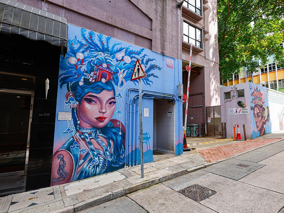 在太平山街Lauren YS创作的街头壁画上，一位女士戴着精致蓝色头饰。 