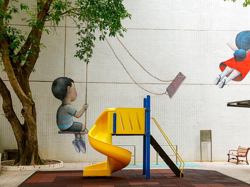 游乐场里有一幅壁画，画中两个孩子在秋千上玩耍。 
