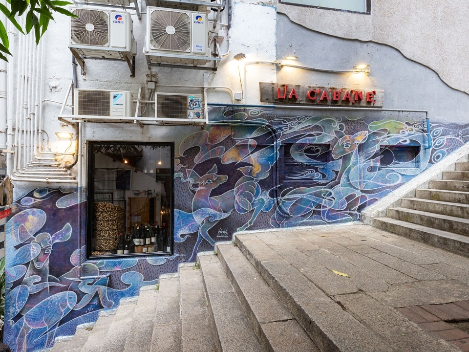 善庆街楼梯旁的墙上有一幅蓝色和紫色的壁画。